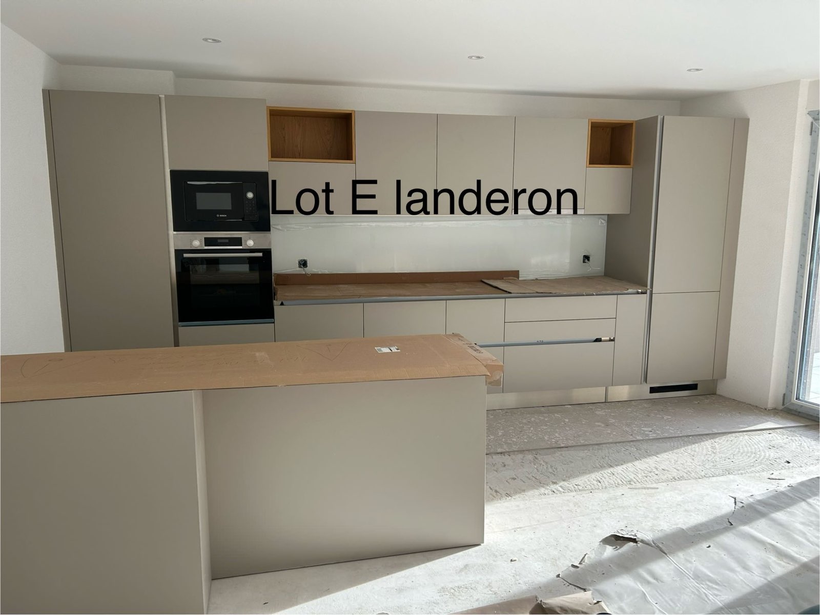 Cuisine beige avec îlot central et niches en chêne